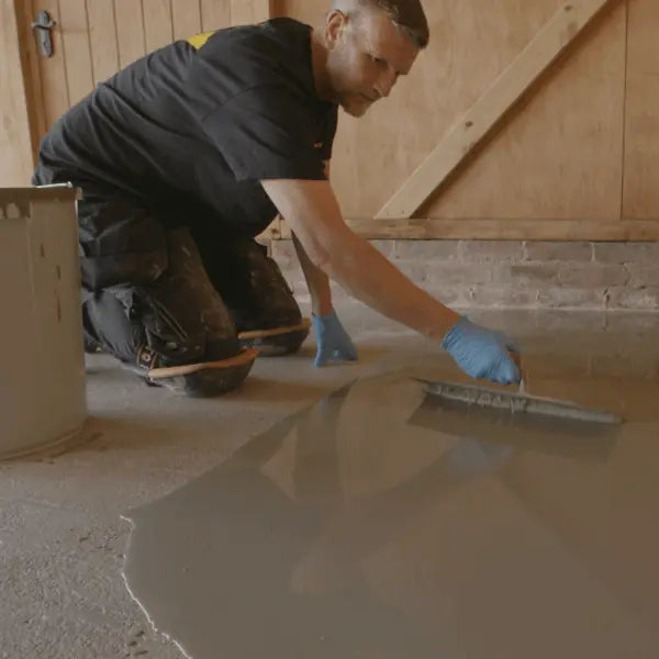 Person applying a layer of material on a floor
