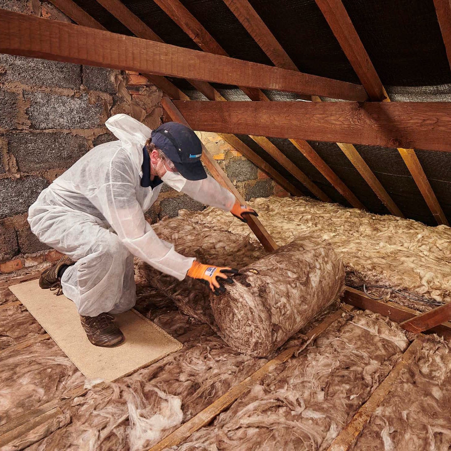 A rolled loft insulation from Knauf Insulation, being installed in a loft